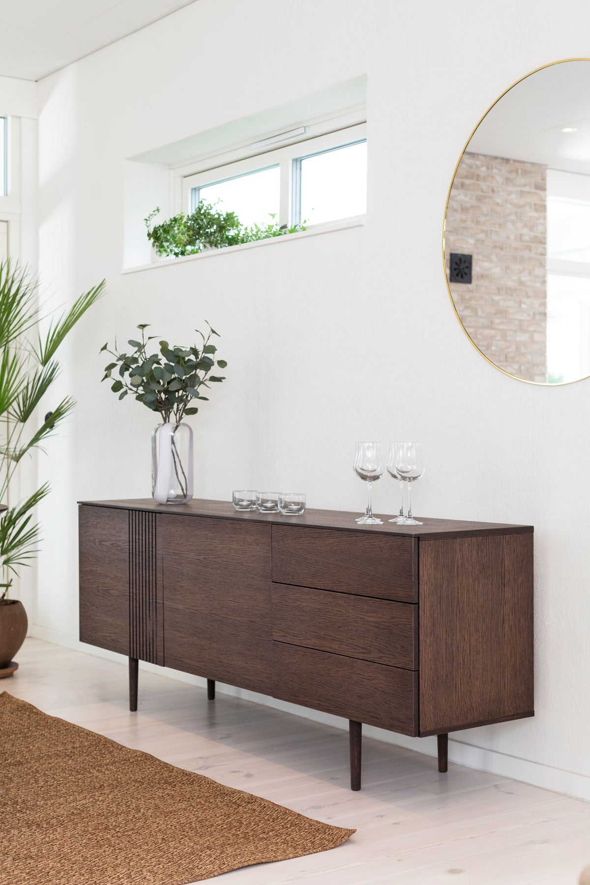 Joel Sideboard | Rökoljad Ek i ett modernt hus med vitväggar och stora speglar.