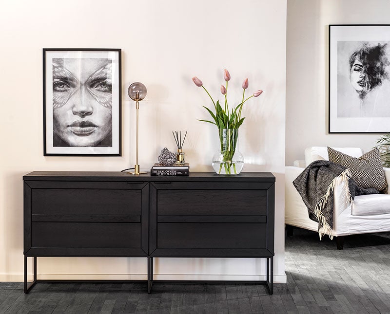 Everett Sideboard 160 i svart ek med en bordslampa, en vas med blommor och dekorativa detaljer
