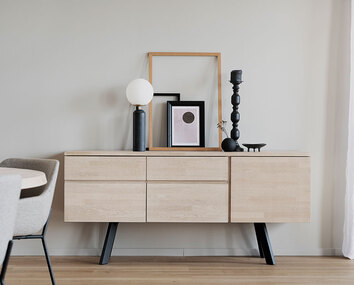 Fred Sideboard i vitpigmenterad ek med bordslampa, ljusstake och tavelramar