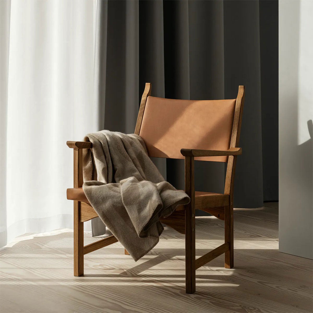 Miljöbild på fåtöljen Caryngo. Här visad i oljad ek, med sits i naturfärgat läder. 