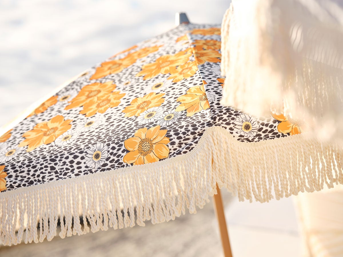 Gatsby Parasoll i färgen Buttercup Dot på strand med hav i bakgrunden