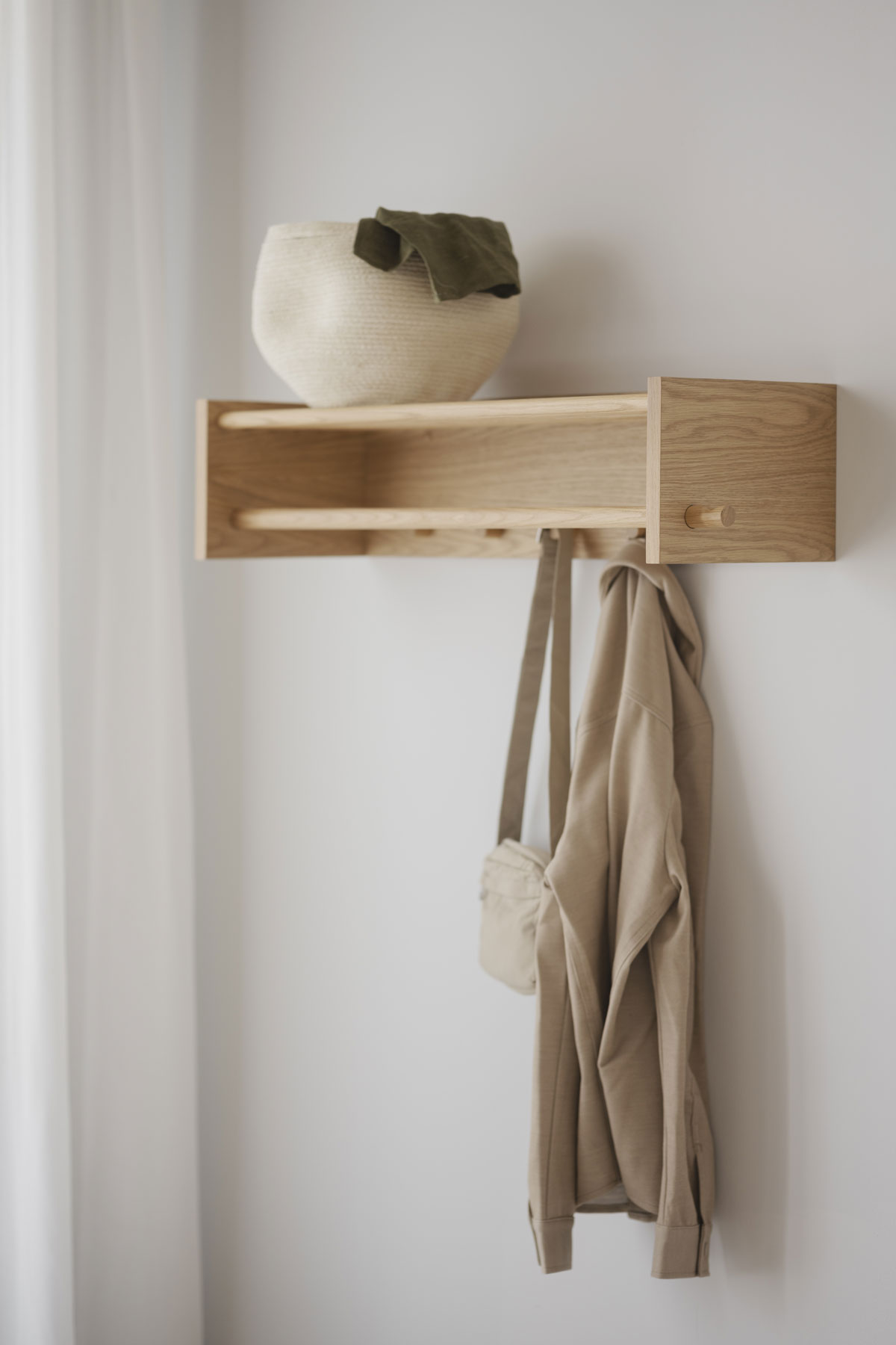 Hillmond Hatthylla Ek med flätad korg, en väska och en jacka