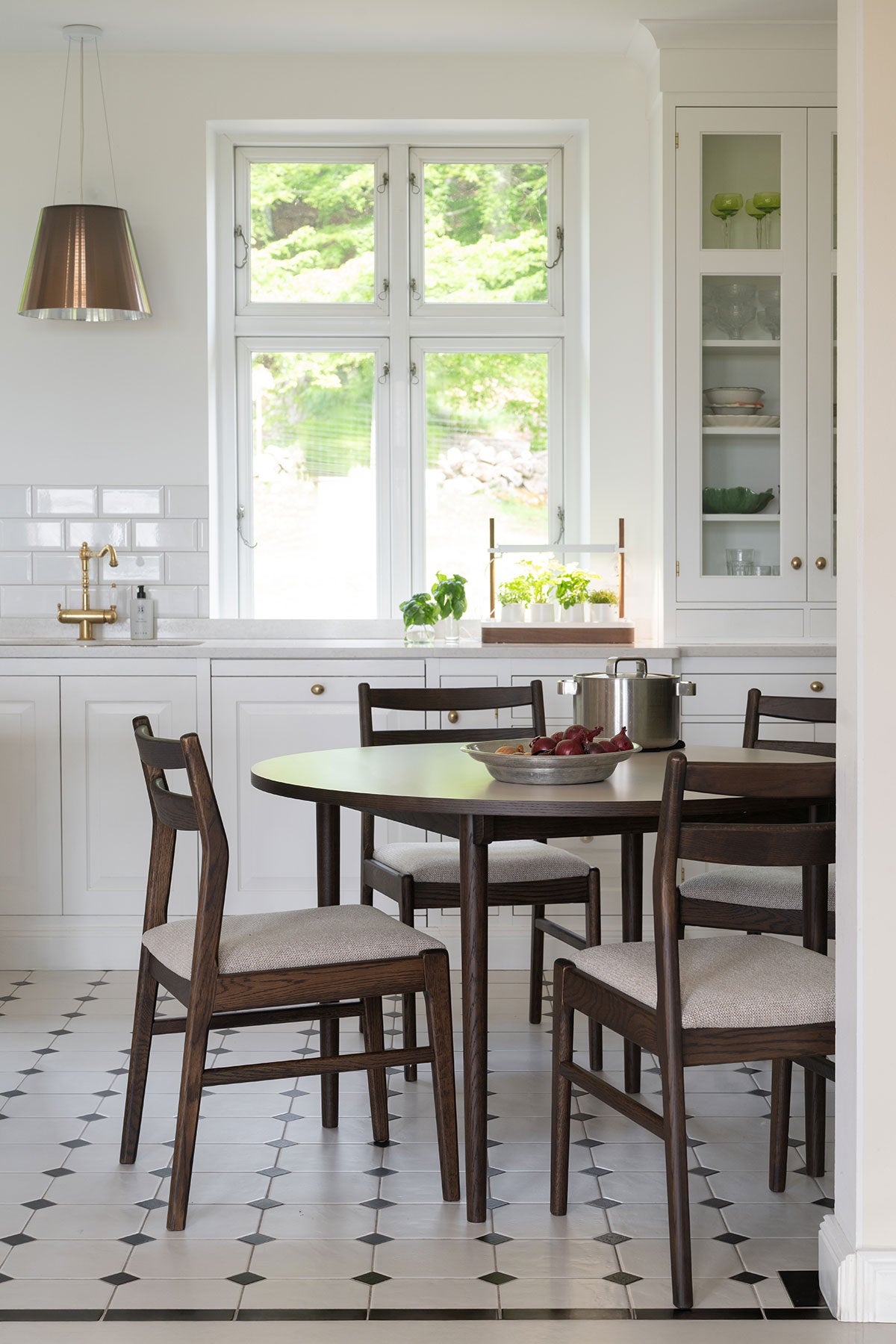 Kerwin Stol i brun ek med ljusbeige tyg vid runt matbord i kök