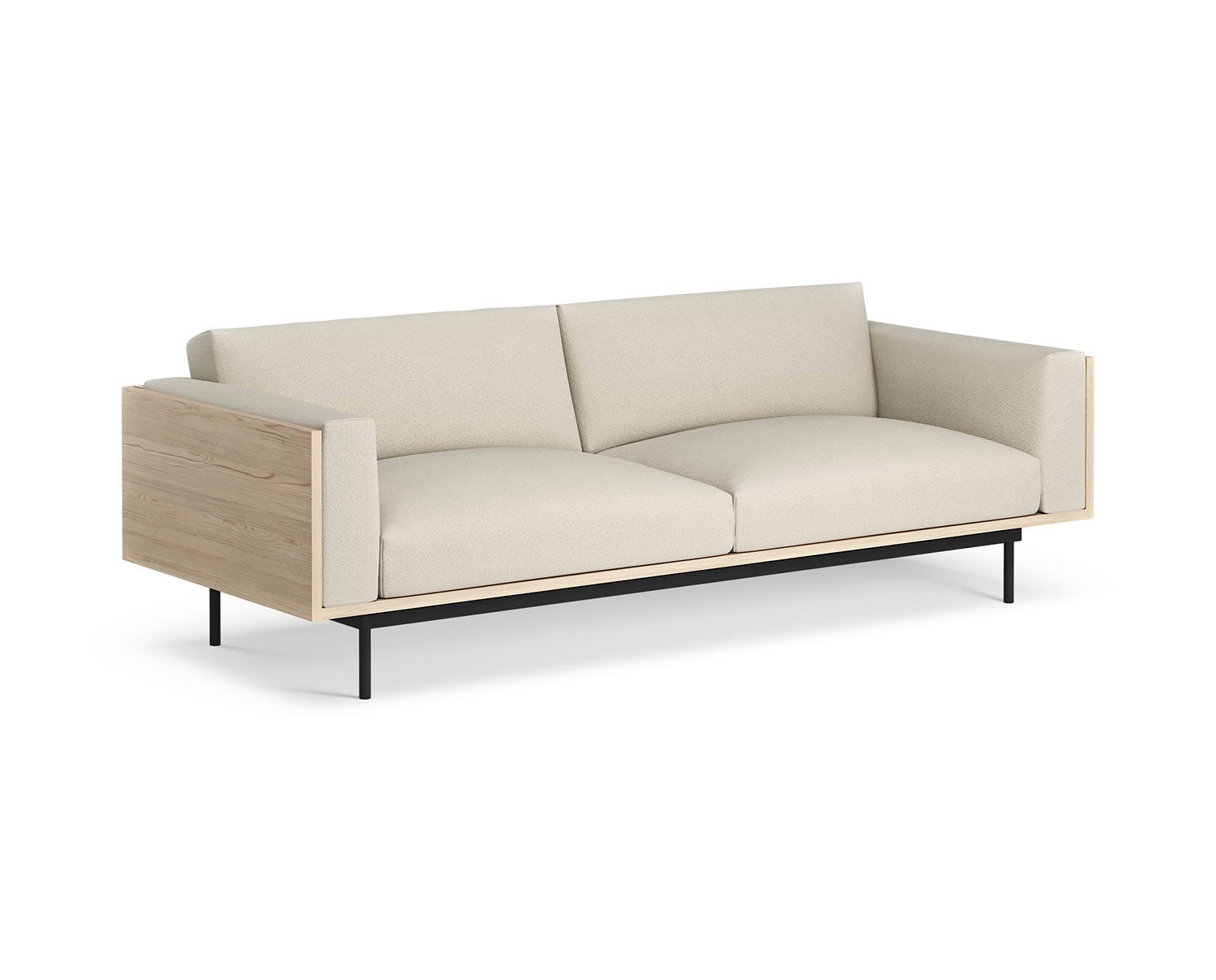 Soffan Wood, i tresitsig modell. Soffan är klädd i tyget Patina 02, med ben av svart stål (strukturlack). Gavlarna är i utförande ask, natur. 