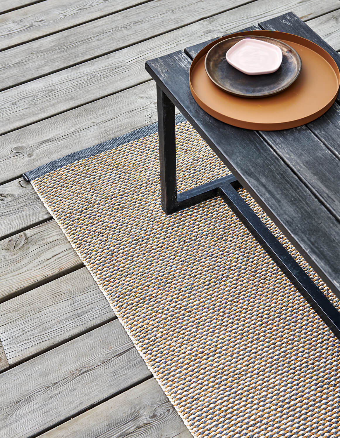 Pappelinas Matta Effi i färgen granit under en svart bänk