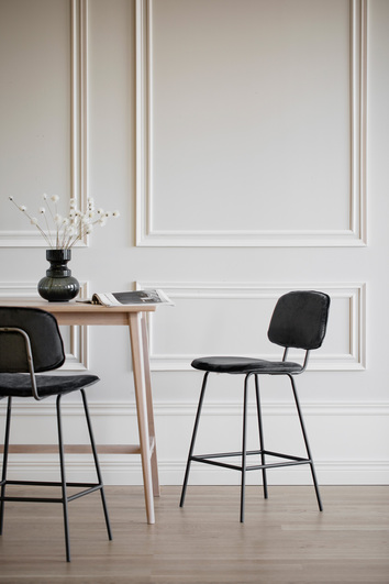 Bryan Barstol i svart sammet, en sekelskifteslägenhet runt ett ljust barbord.