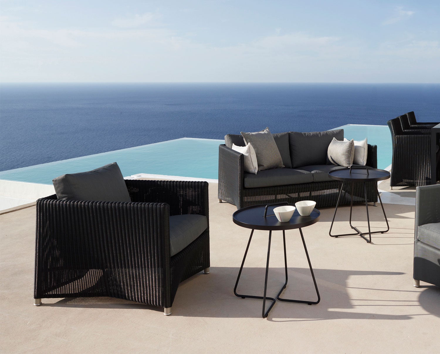 Diamond Loungefåtölj Graphite vid poolkant med runt sidobord