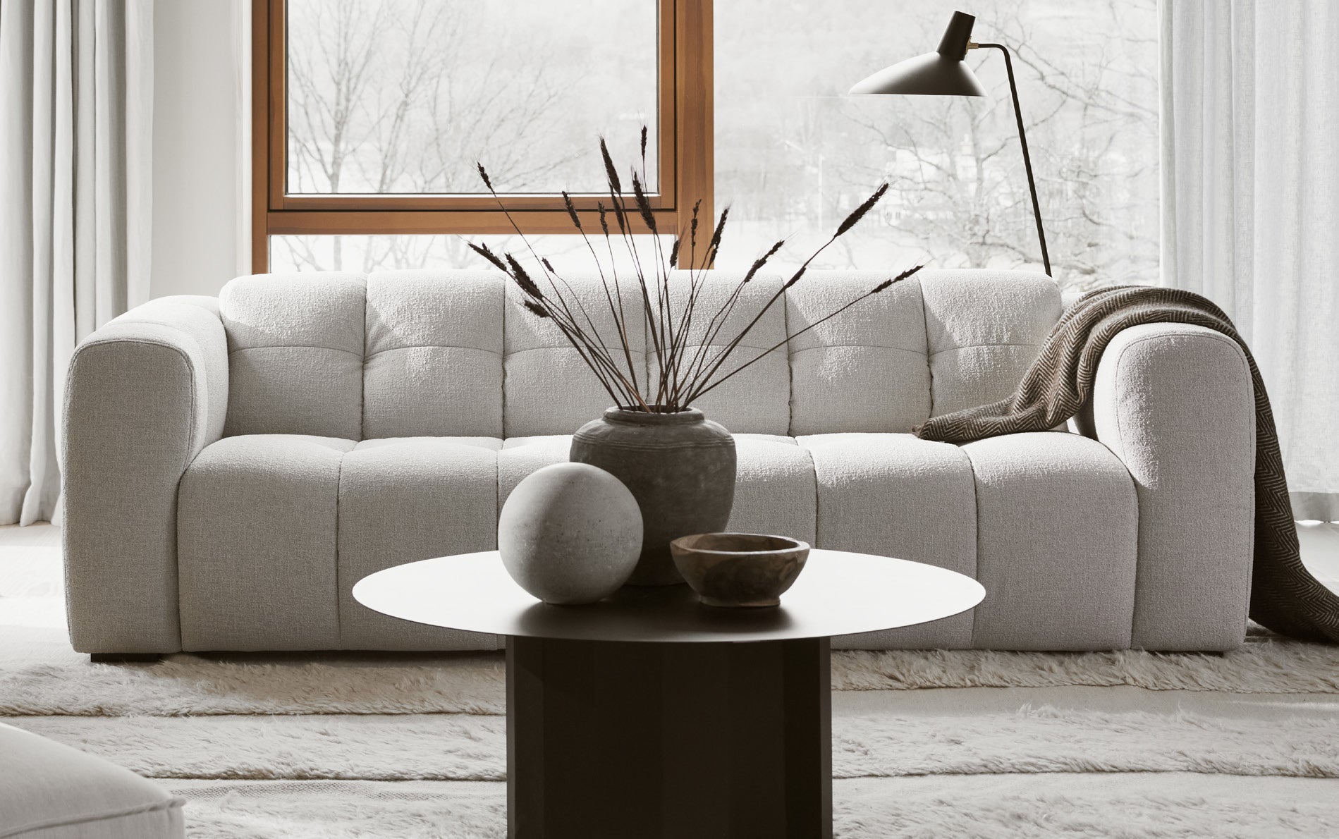 Alps soffa ståendes i ett ljust och mysigt vardagsrum med ett runt litet soffbord