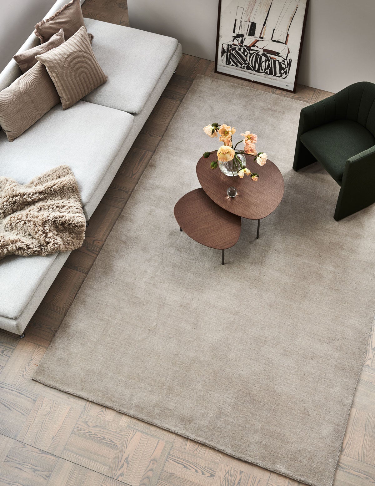 Solid Matta Beige i vardagsrum inrett med två sidobord, en fåtölj och en soffa med dekorativa textilier